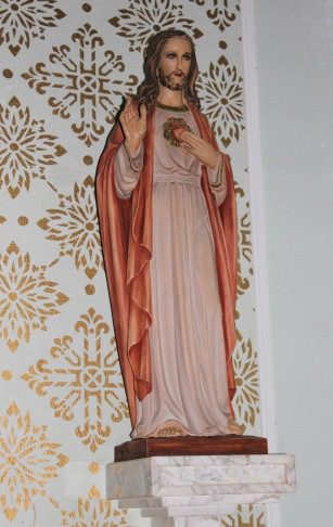 A statue of jesus christ is shown in front of a wall.