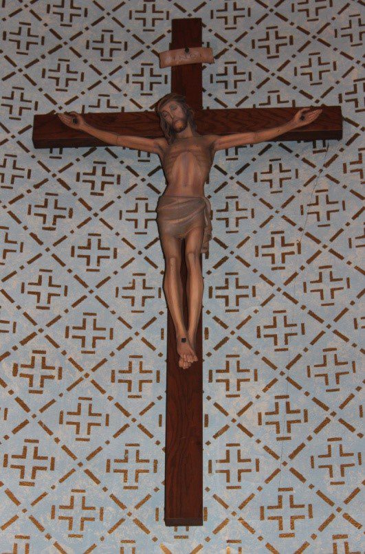 A cross with jesus on it is shown in the middle of a room.