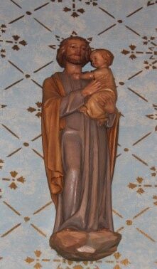 A statue of jesus holding a child in his arms.