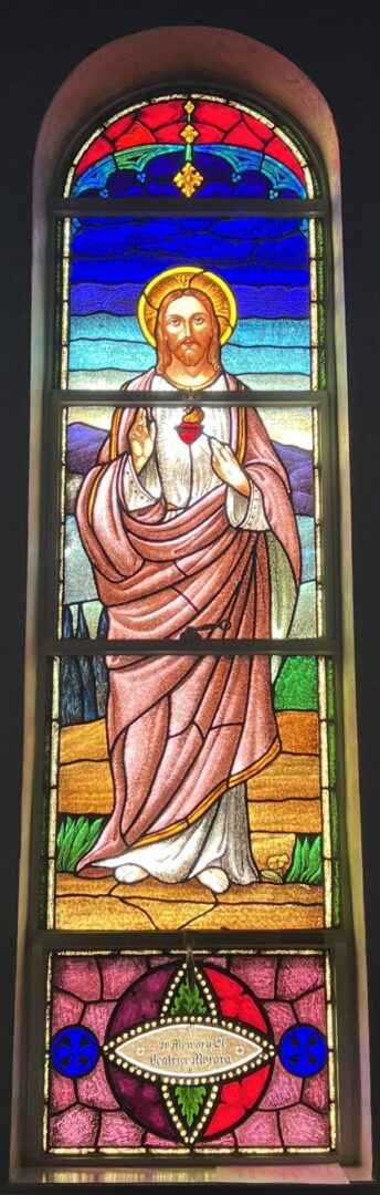 A stained glass window of jesus holding the hand of god.