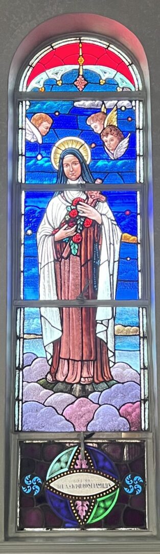 A stained glass window of saint joseph holding roses.