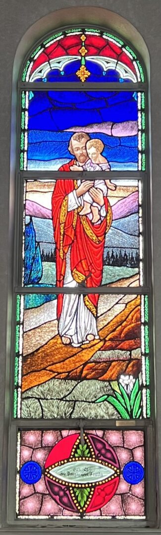 A stained glass window of jesus holding the infant christ.