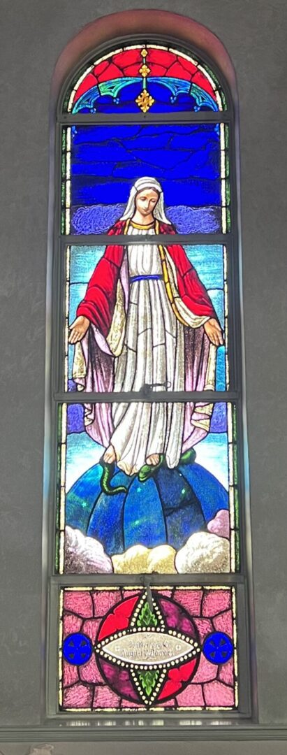 A stained glass window of the virgin mary.