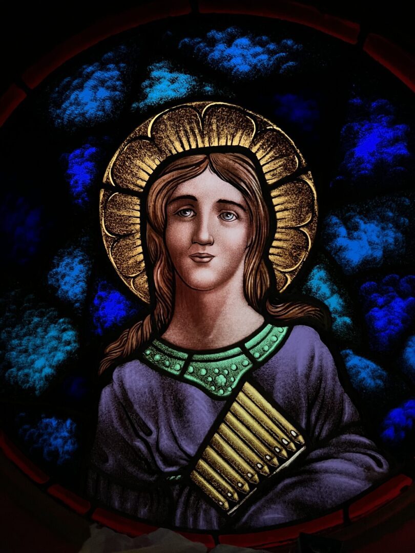 A stained glass window of mary with the halo around her head.