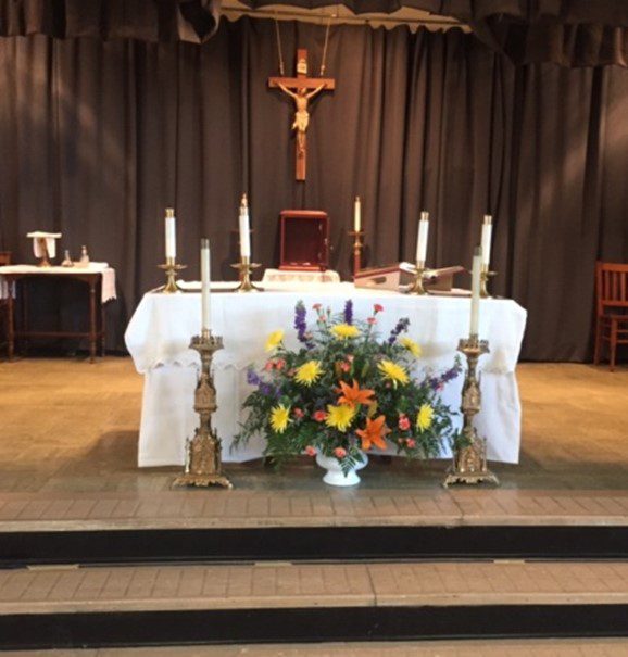 A church altar with flowers and candles on it.