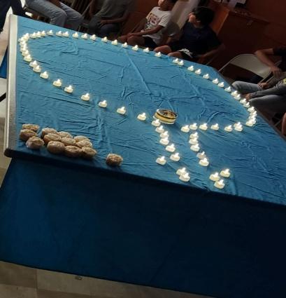 A table with candles on it and people around